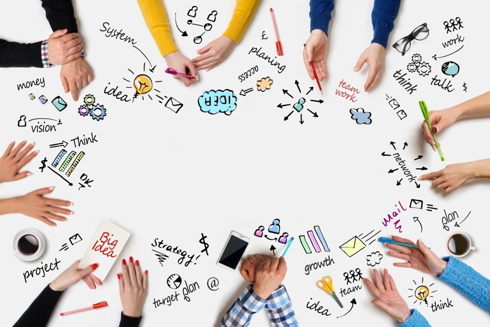 A group of people sitting around a table with pens and markers.