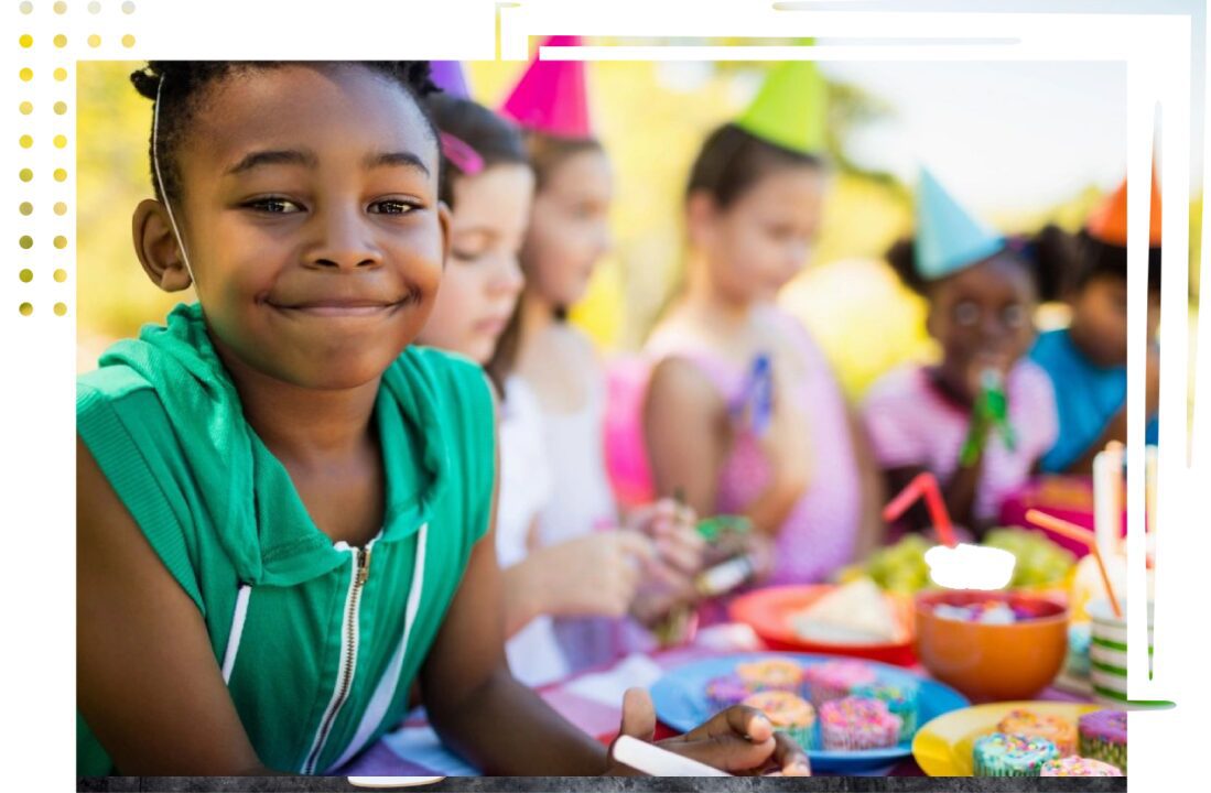 A group of children sitting at a table with food.