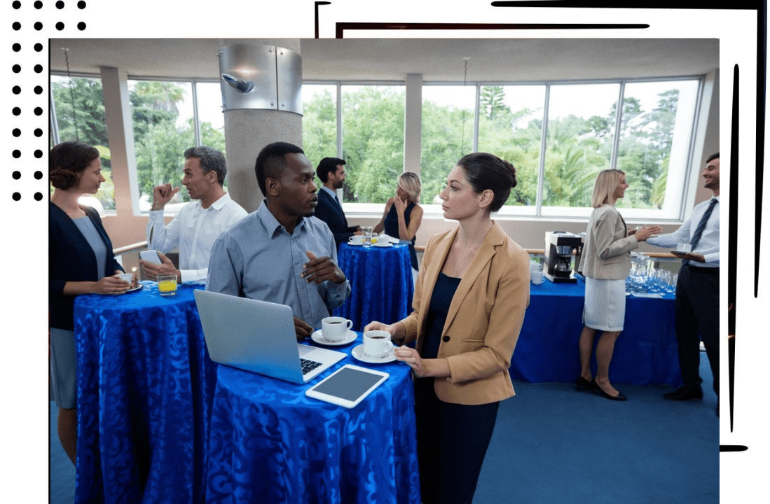 A man and woman standing at tables with laptops.