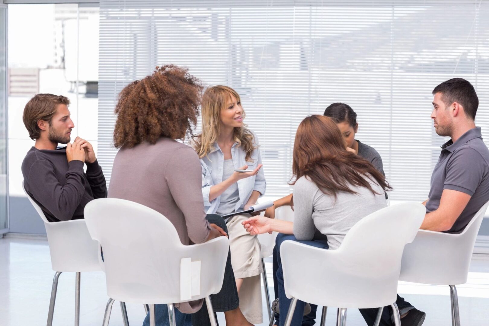 A group of people sitting around in chairs.